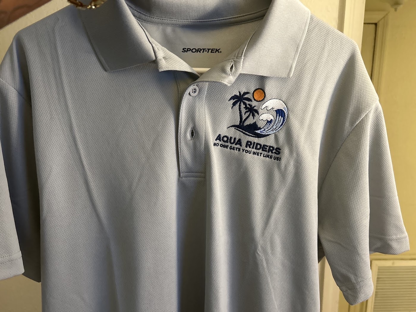 Light blue performance polo with an embroidered logo